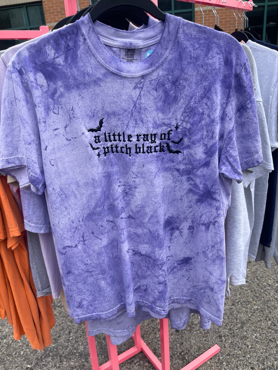 Purple tie-dye T-shirt embroidered with A Little Ray of Pitch Black