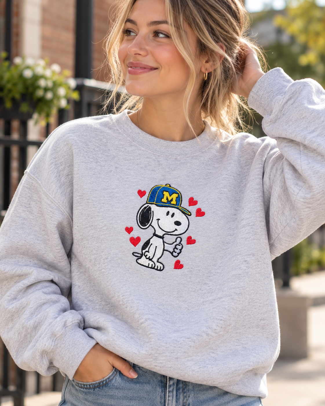Model wearing maize and blue dog embroidered sweatshirt